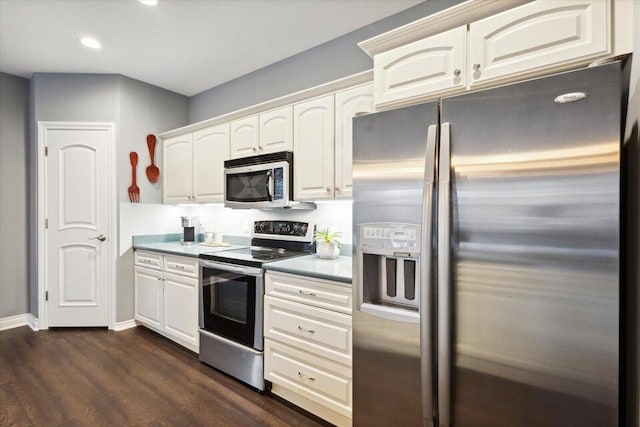 kitchen with stainless steel appliances, dark hardwood / wood-style floors, and white cabinets