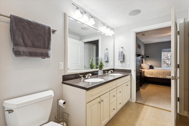 bathroom with vanity, toilet, and a textured ceiling