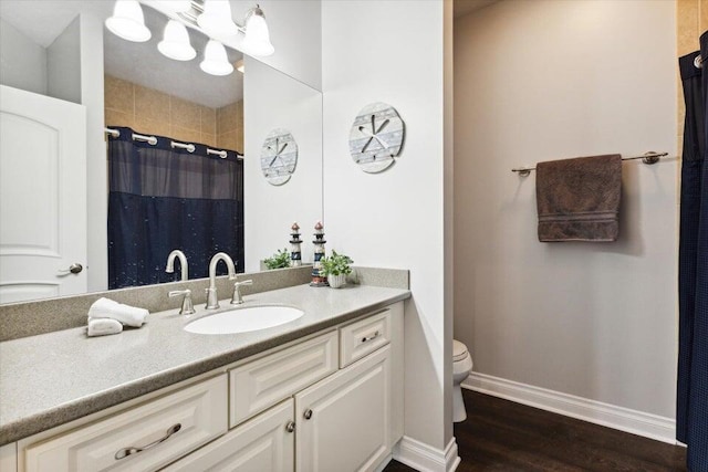 bathroom featuring vanity, toilet, curtained shower, and hardwood / wood-style floors