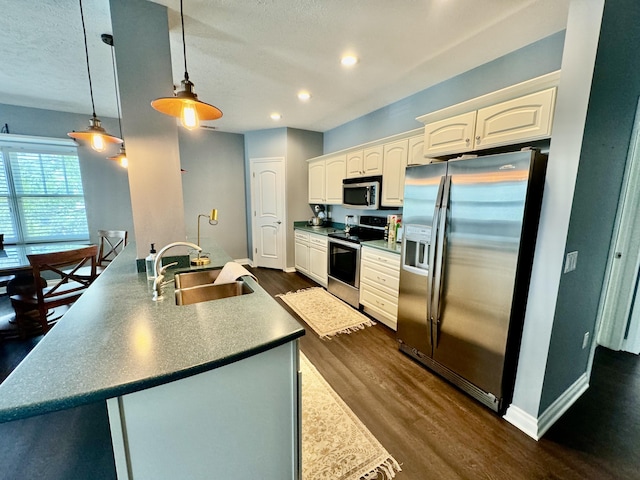 kitchen with a sink, white cabinetry, appliances with stainless steel finishes, baseboards, and dark wood-style flooring