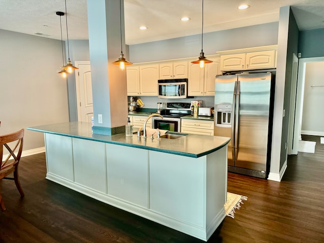 kitchen with dark hardwood / wood-style floors, appliances with stainless steel finishes, white cabinets, and pendant lighting