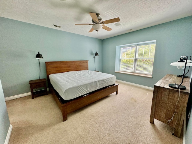 carpeted bedroom with a textured ceiling and ceiling fan