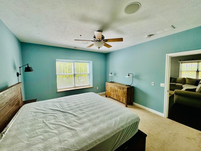 bedroom featuring carpet flooring, ceiling fan, and a textured ceiling