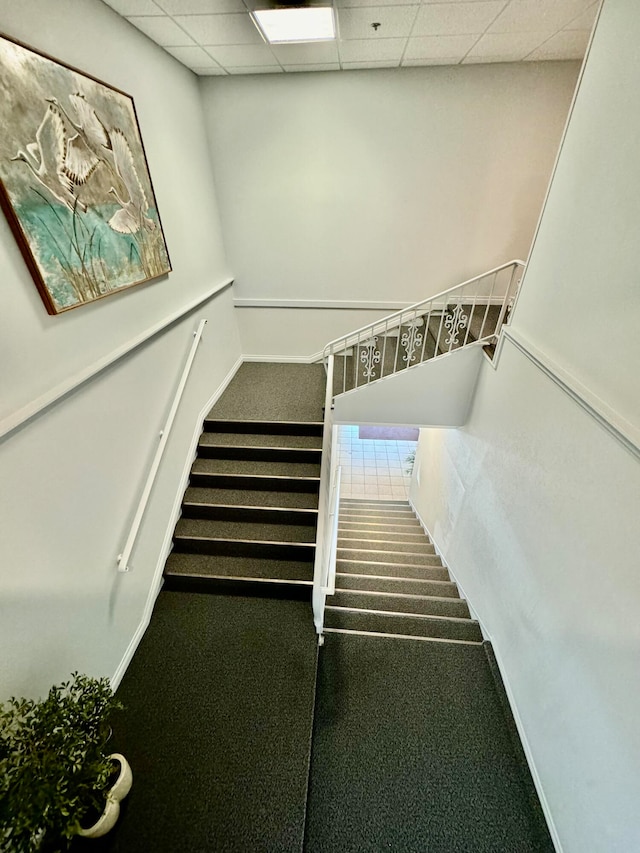 stairway featuring a paneled ceiling