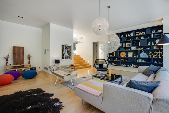 living room with built in shelves and hardwood / wood-style flooring