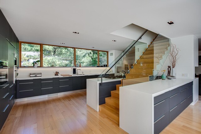 kitchen with sink, a center island, and light wood-type flooring