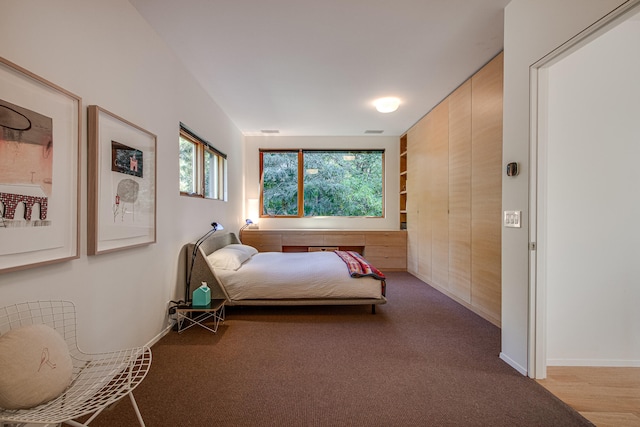 carpeted bedroom featuring wooden walls