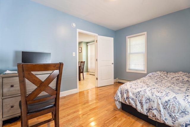 bedroom featuring light wood-type flooring and a baseboard radiator