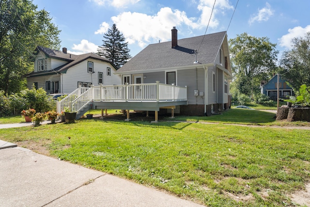 rear view of property with a wooden deck and a lawn