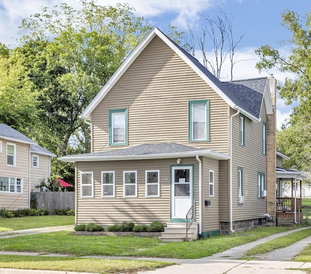 view of front of home with a front lawn, entry steps, fence, a shingled roof, and a chimney