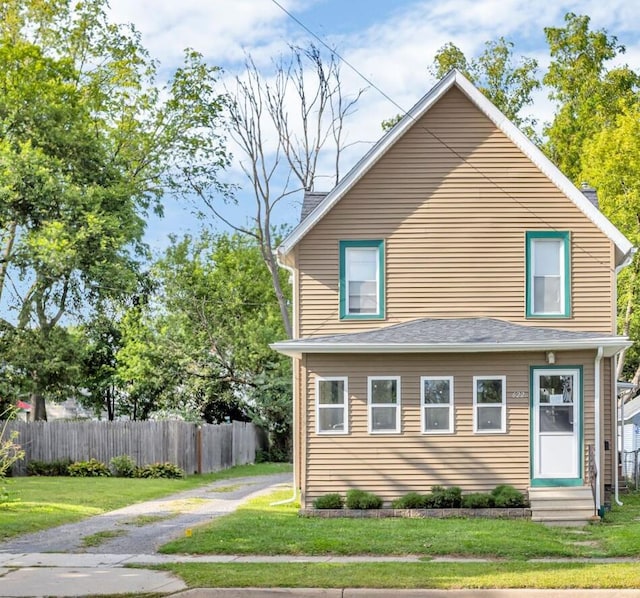 exterior space featuring a front yard, fence, driveway, a chimney, and entry steps