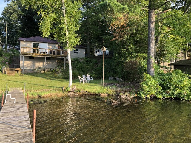 view of dock featuring a water view and a yard