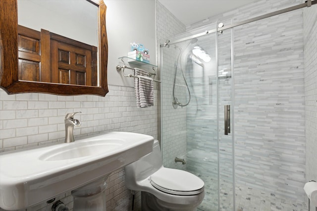 bathroom featuring a shower with shower door, toilet, tile walls, and decorative backsplash