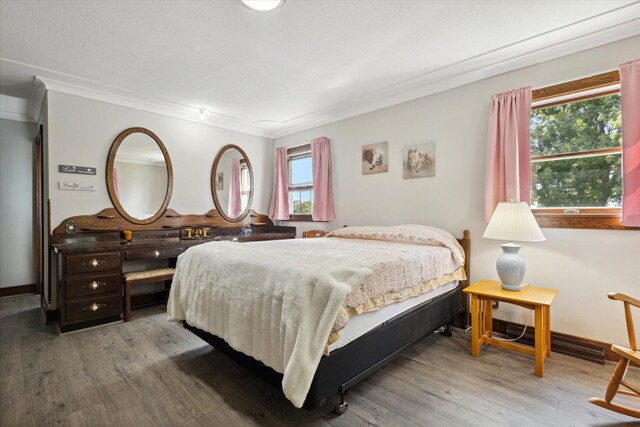 bedroom with hardwood / wood-style floors and crown molding