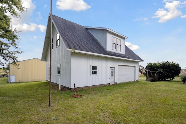 rear view of property featuring a yard and a garage