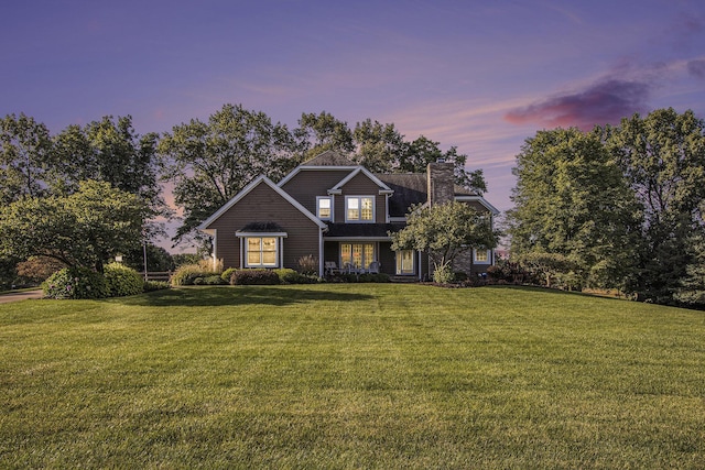 view of front of home featuring a yard and a chimney