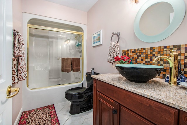 full bathroom featuring vanity, combined bath / shower with glass door, backsplash, toilet, and tile patterned floors