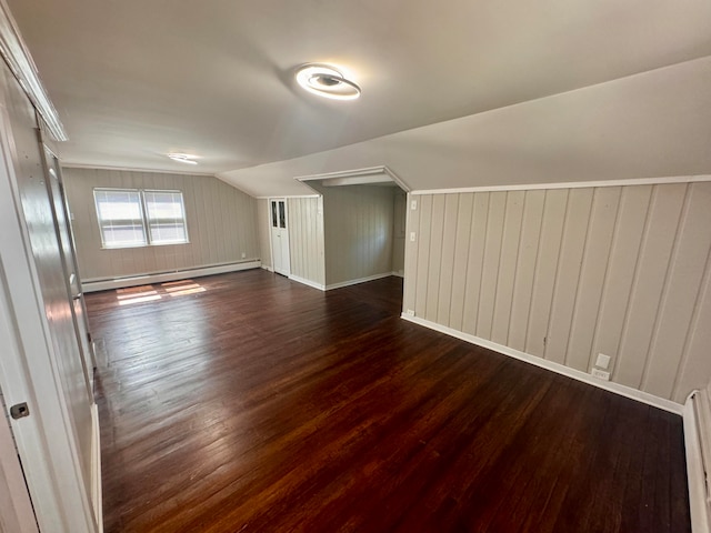 additional living space featuring a baseboard heating unit, dark hardwood / wood-style flooring, and lofted ceiling