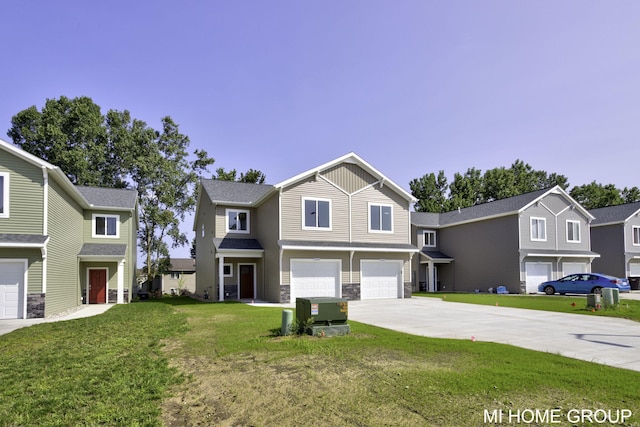 view of front of home with a front lawn, driveway, stone siding, a residential view, and a garage