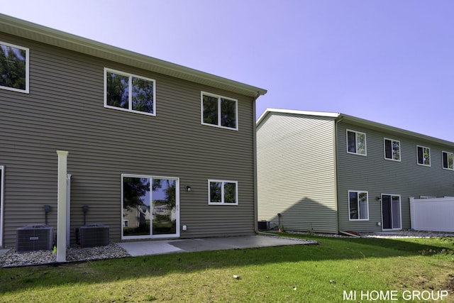 rear view of house featuring a lawn, central AC, and a patio