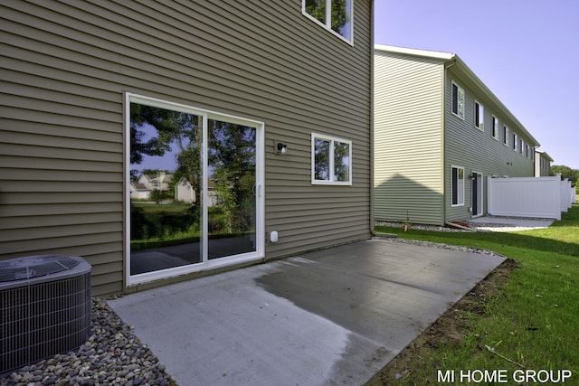 back of house with a patio area, central AC unit, a lawn, and fence