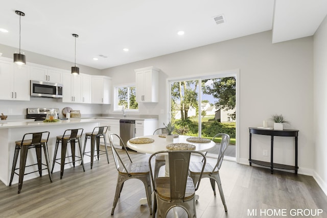 dining room featuring recessed lighting, light wood-style floors, visible vents, and baseboards