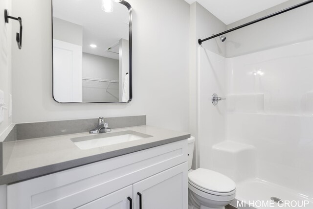 bathroom with a shower, toilet, and vanity