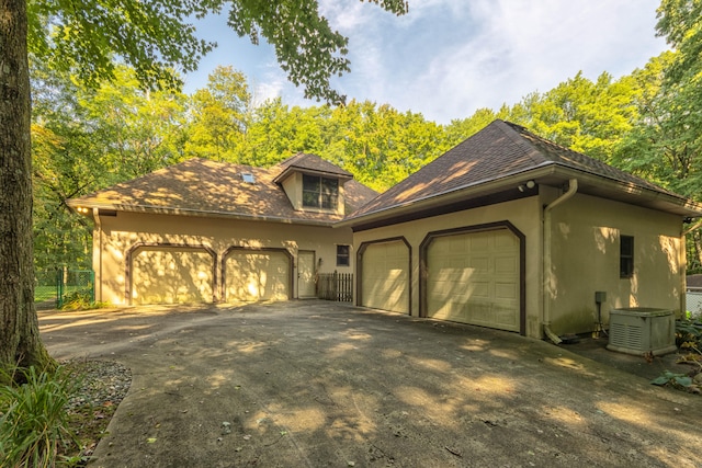 view of property exterior featuring a garage and central AC