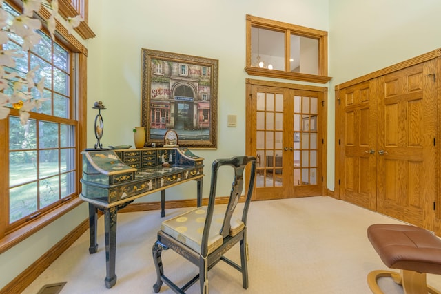 carpeted home office with french doors and a healthy amount of sunlight