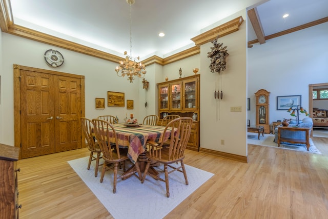 dining space with crown molding, light hardwood / wood-style flooring, and a notable chandelier