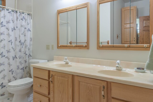 bathroom featuring walk in shower, toilet, and vanity