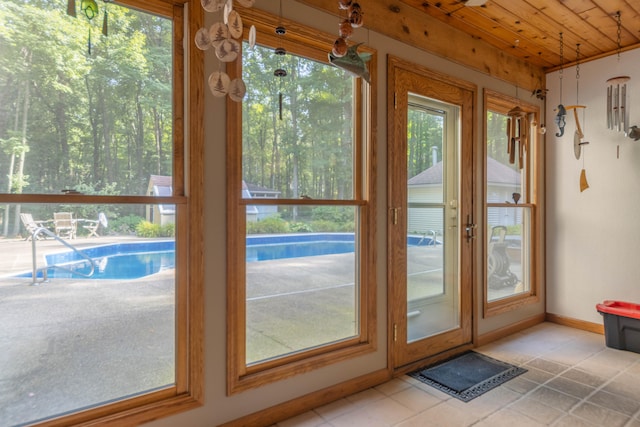 doorway featuring plenty of natural light, light tile patterned floors, and wooden ceiling