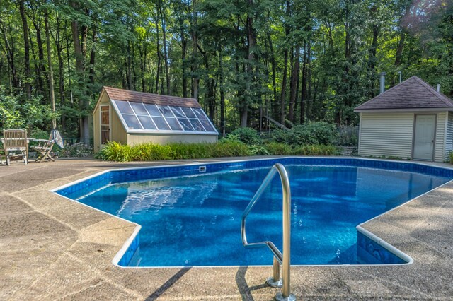 view of pool with a storage unit and a patio area