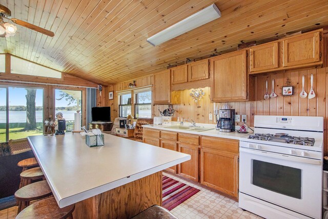 kitchen with a breakfast bar area, wood ceiling, white gas stove, lofted ceiling, and ceiling fan