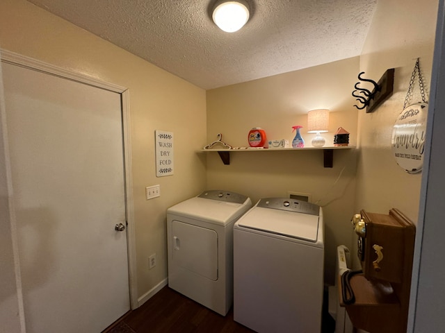 laundry room with dark wood-type flooring, a textured ceiling, and washer and clothes dryer