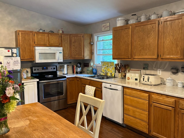 kitchen featuring vaulted ceiling, stainless steel appliances, sink, and dark hardwood / wood-style floors