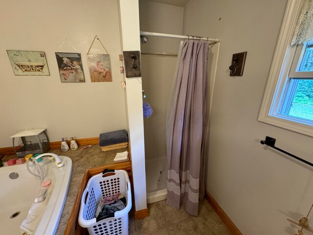 bathroom featuring a shower with curtain, sink, and tile patterned floors