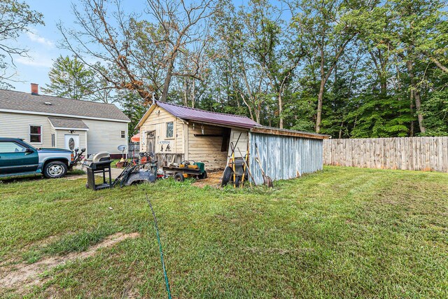 6991 E Apple Ave, Muskegon, MI 49442 - exterior space featuring an outdoor structure, fence, metal roof, and a lawn