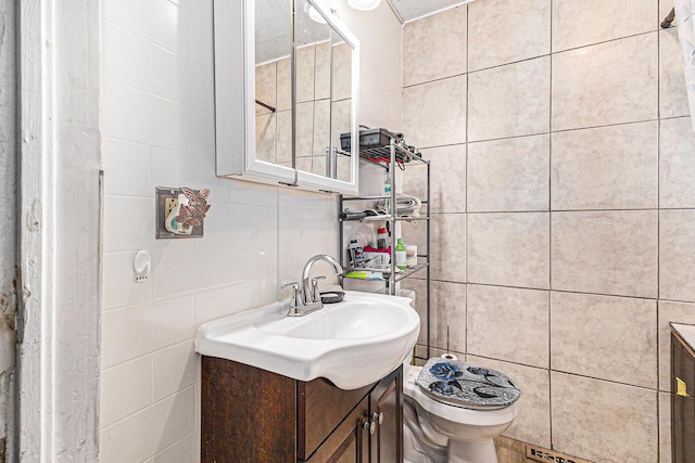 6991 E Apple Ave, Muskegon, MI 49442 - bathroom featuring toilet, tasteful backsplash, vanity, and tile walls