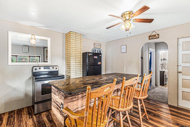 6991 E Apple Ave, Muskegon, MI 49442 - kitchen featuring dark wood-style floors, freestanding refrigerator, electric range, ceiling fan, and arched walkways