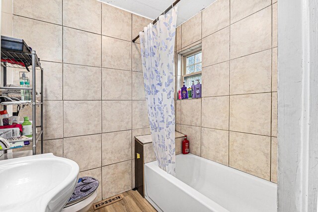 6991 E Apple Ave, Muskegon, MI 49442 - bathroom featuring a sink, tile walls, shower / tub combo with curtain, and wood finished floors