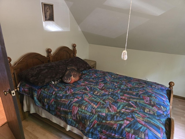 bedroom featuring hardwood / wood-style flooring and vaulted ceiling