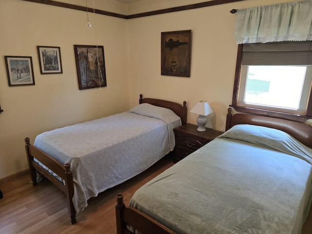 bedroom with ornamental molding and dark hardwood / wood-style floors