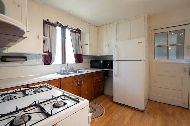 kitchen with white appliances, light hardwood / wood-style floors, and sink