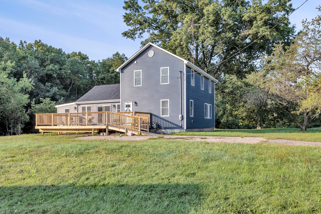 rear view of property with a lawn and a deck