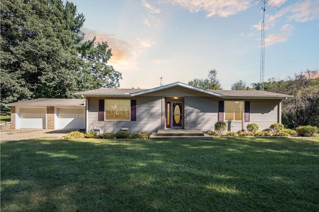 single story home featuring a garage and a yard