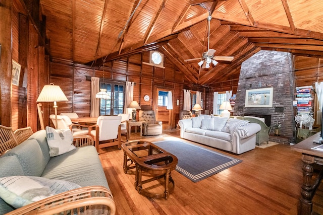 living room featuring high vaulted ceiling, a brick fireplace, wood ceiling, and hardwood / wood-style flooring