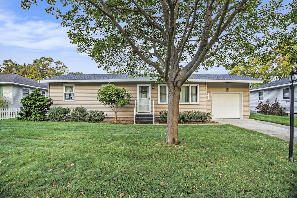 ranch-style house featuring a garage and a front yard