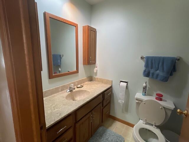 bathroom with tile patterned flooring, vanity, and toilet