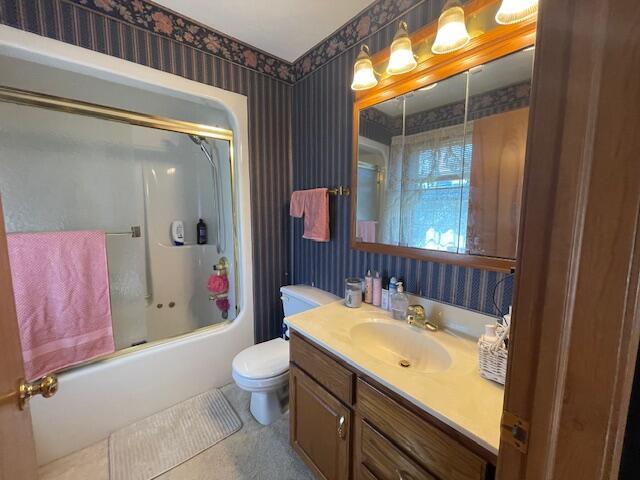 full bathroom with vanity, toilet, and bath / shower combo with glass door